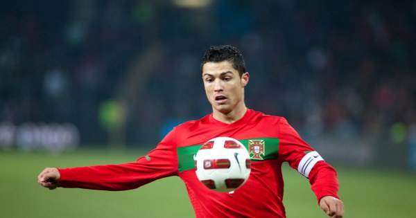 Athletic soccer player celebrating goal with arms wide open.