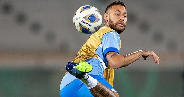 Skilful soccer player performing trick on colorful football pitch.